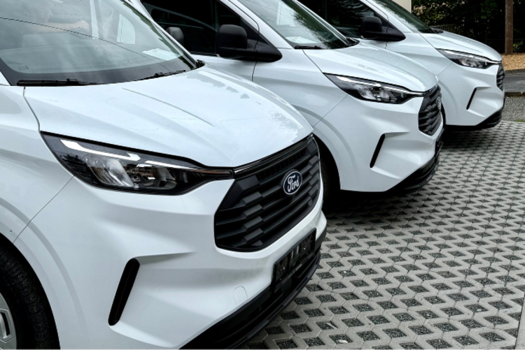 Drei neue weiße Ford Kleinbusse stehen auf dem Parkplatz vor dem DRK KV Klingenthal e.V.