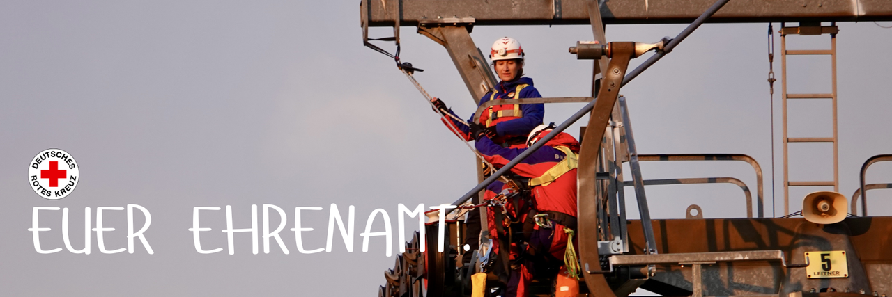 Zwei Mitglieder der Bergwacht Schöneck stehen auf einem Liftmast und bereiten die Rettung der im Lift festsitzenden Personen vor.