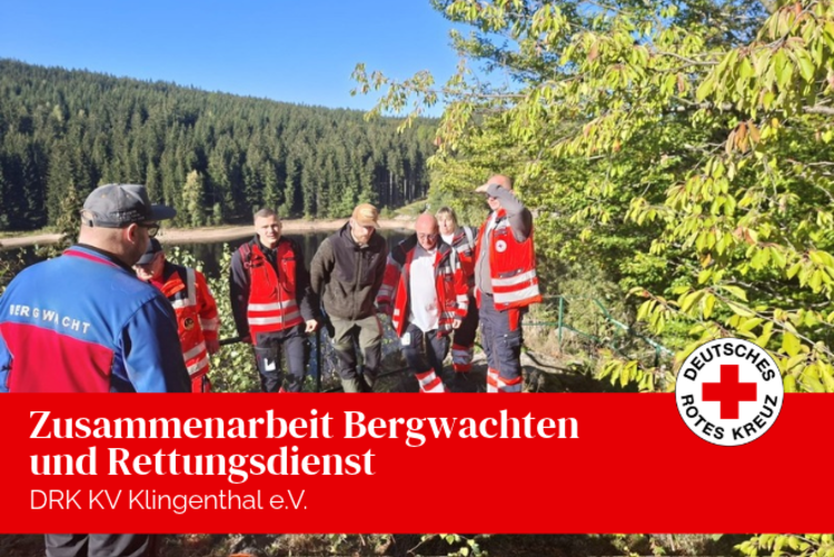 Die Kameradinnen und Kameraden der DRK Bergwachten Carlsfeld und Klingenthal/Aschberg sowie die Mitarbeitenden der DRK Rettungsdienst Oberes Vogtland gGmbH stehen zur Abschlussbesprechung zusammen an der Talsperre Sosa.