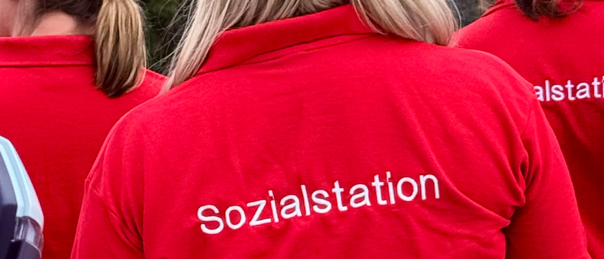 Gesticktes Logo Sozialstation in weißer Farbe auf roten Shirt