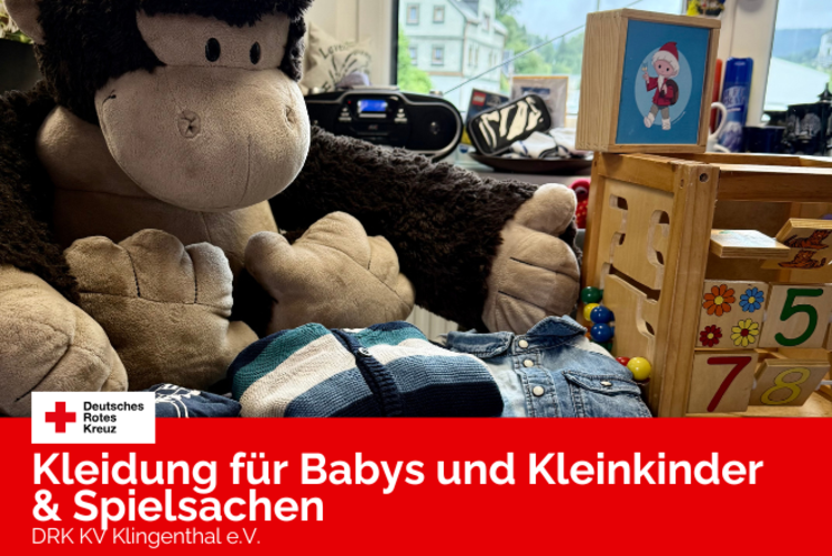 Baby- und Kleinkindkleidung, ein Plüsch-Gorilla und Holzspielzeuge stehen auf einem Tisch