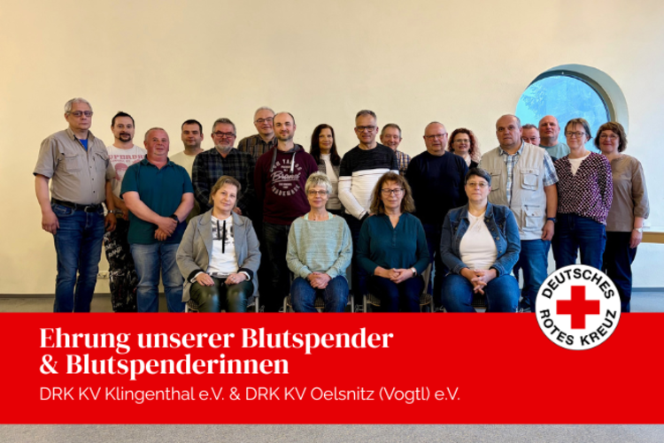 Unsere Blutspenderinnen und Blutspender stehen und sitzen für ein Gruppenfoto im Speisesaal der Jugendherberge Aschberg zusammen.